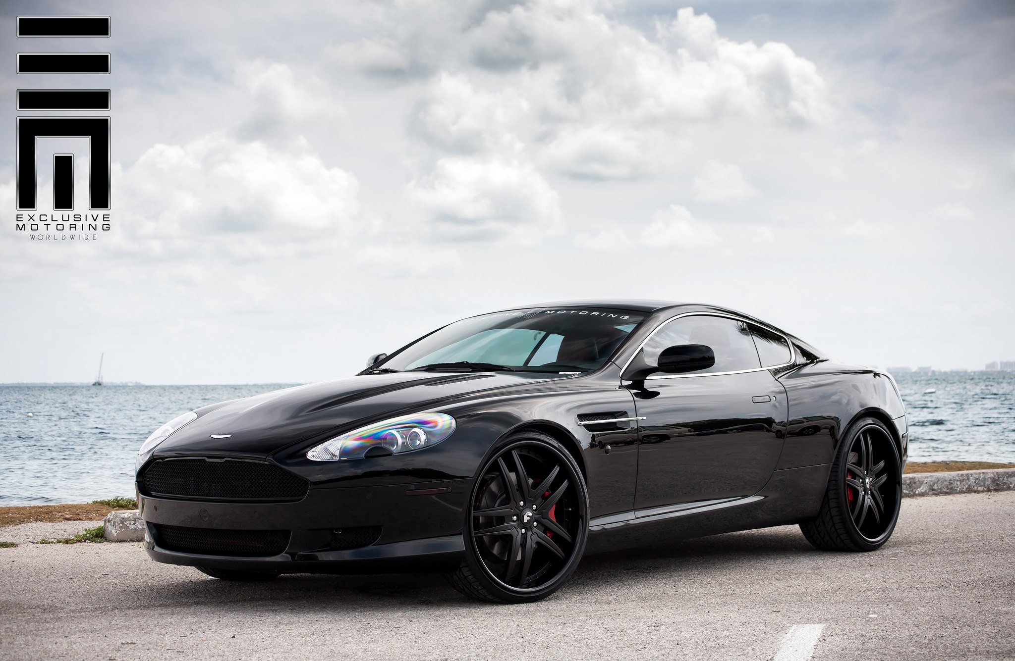 Black menacing Aston Martin DB9 on color matched custom wheels  - Photo by Exclusive Motoring