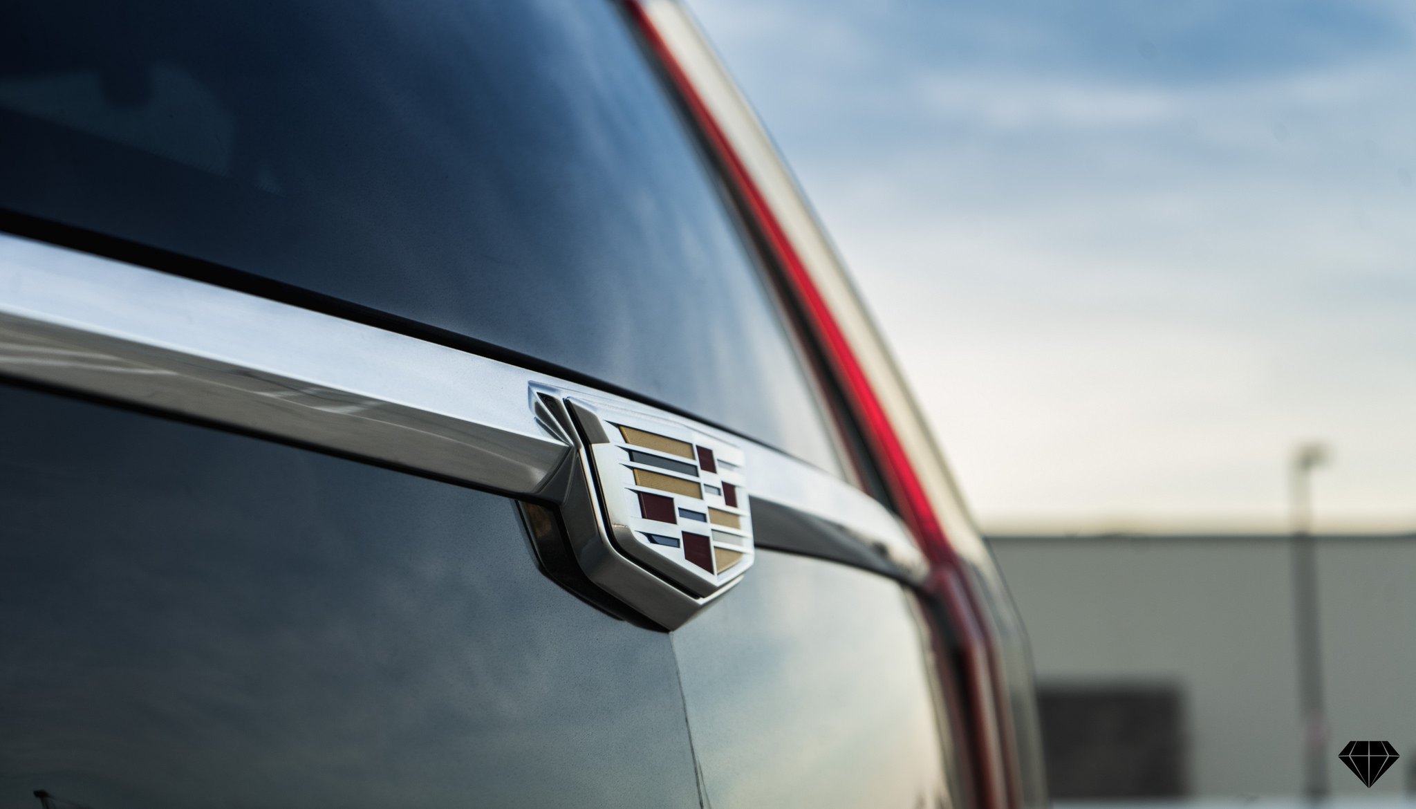 Aftermarket Chrome Emblem on Black Cadillac Escalade - Photo by Blaque Diamond Wheels