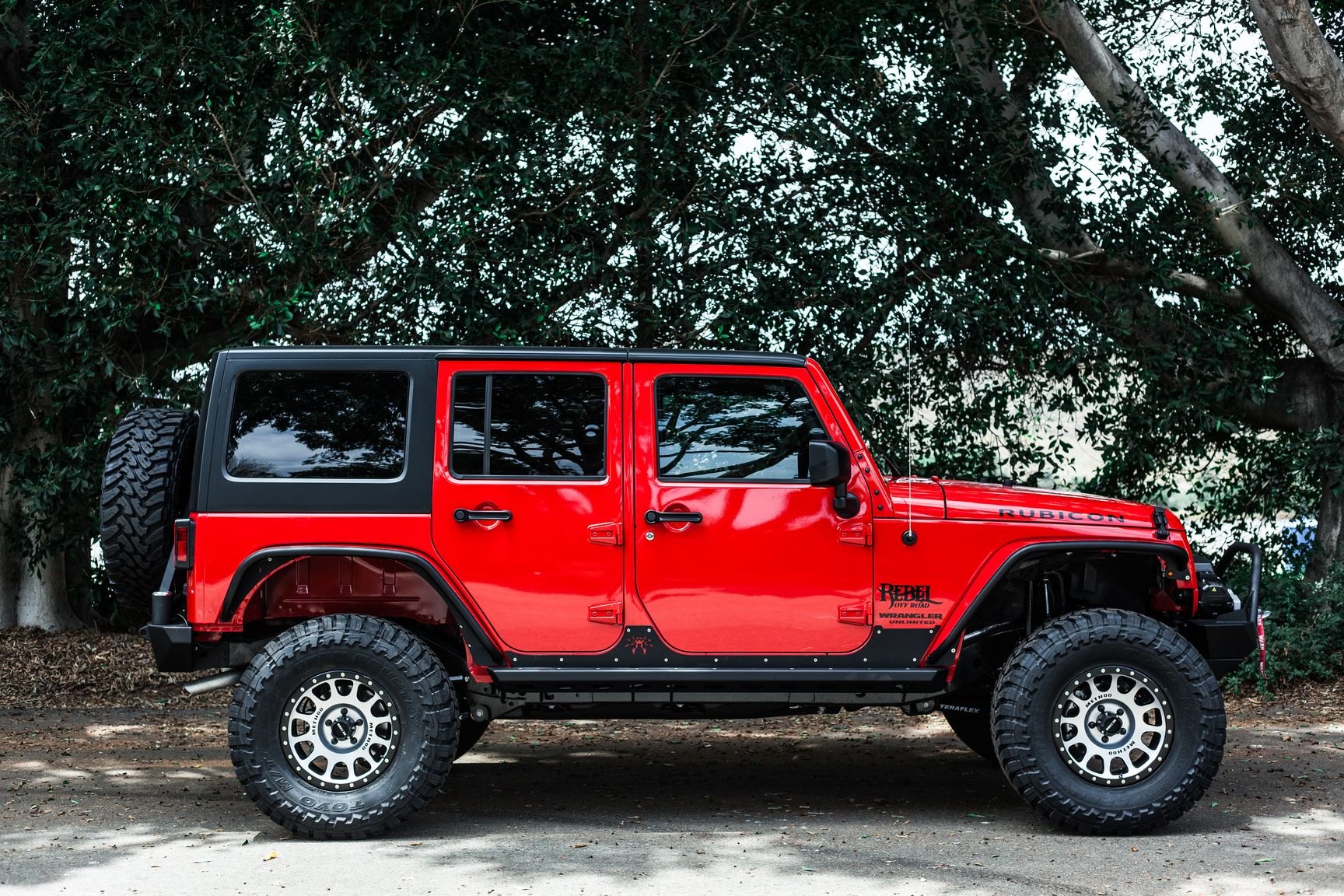 Red Jeep Wrangler Unlimited with Poison Spyder Running Boards - Photo by Rebel Off-Road